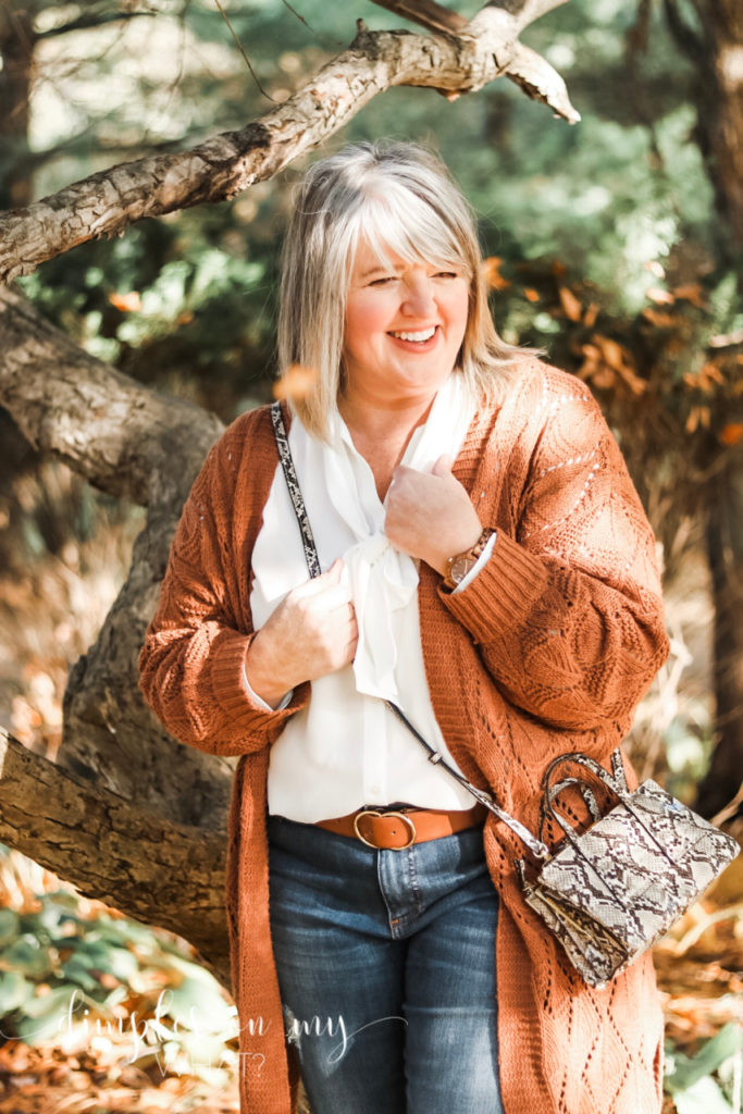 How to wear snake print if you have a snake phobia. A long rust cardigan with denim and a snake print cross body is fall fashion for full figured women. #fallfashion2019 #plussizefashion #agelessstyle  #rustcardigan