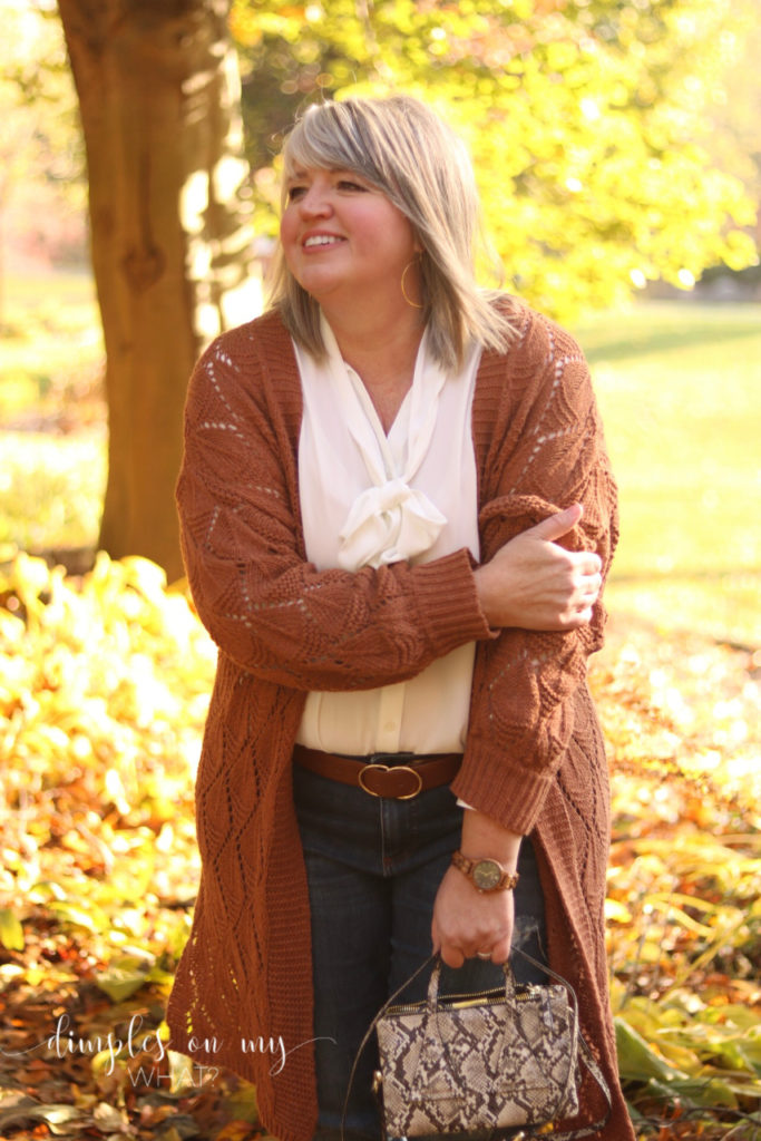 A cozy rust cardigan and denim pair perfectly with a snake print cross-body bag. #plussizefashion  #plussizewomanover50 #over50andfluffyfashion #casualfashionforcurvywomen