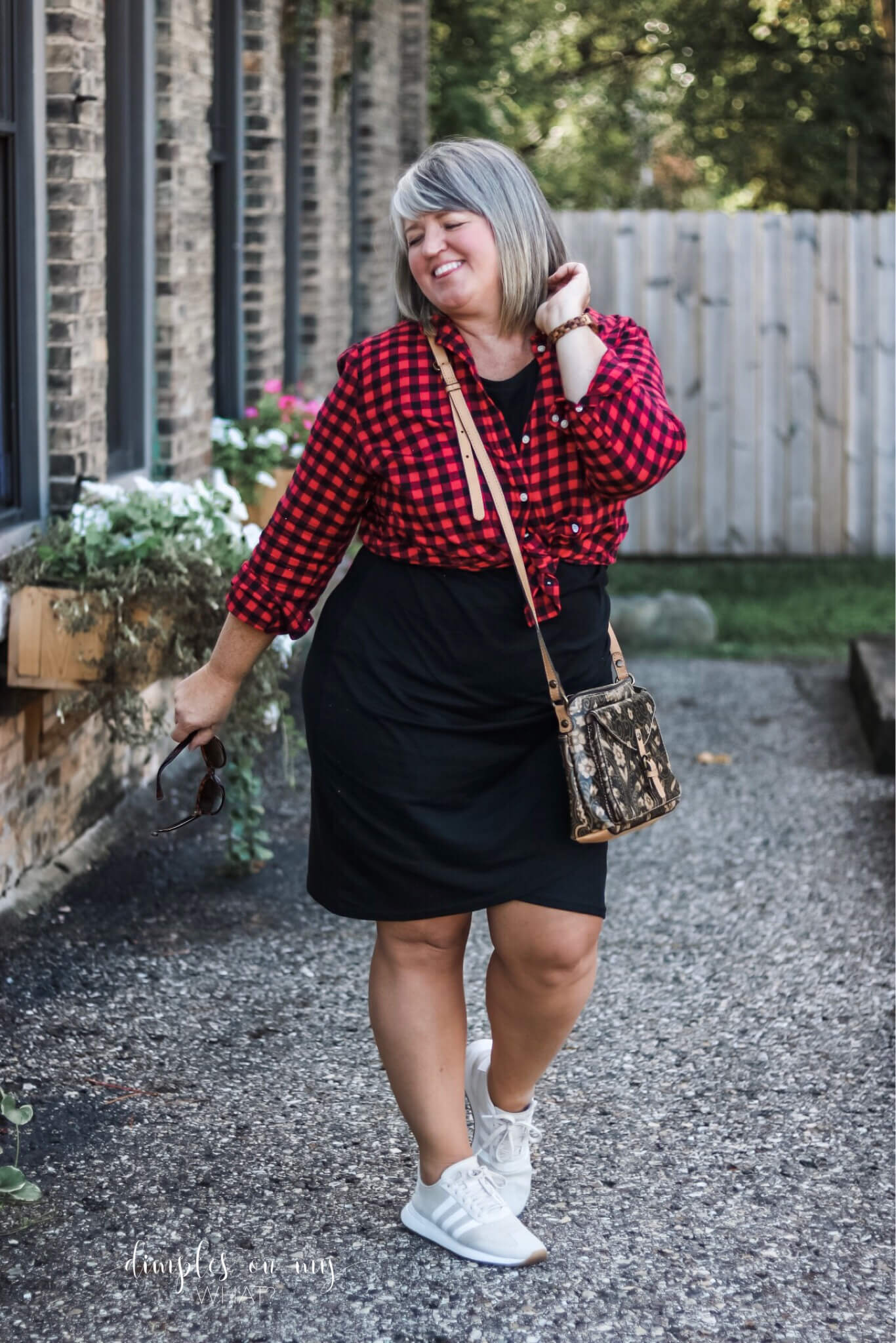 Black knit t-shirt dress with buffalo plaid button-down and sneakers. How to style an LBD for day.