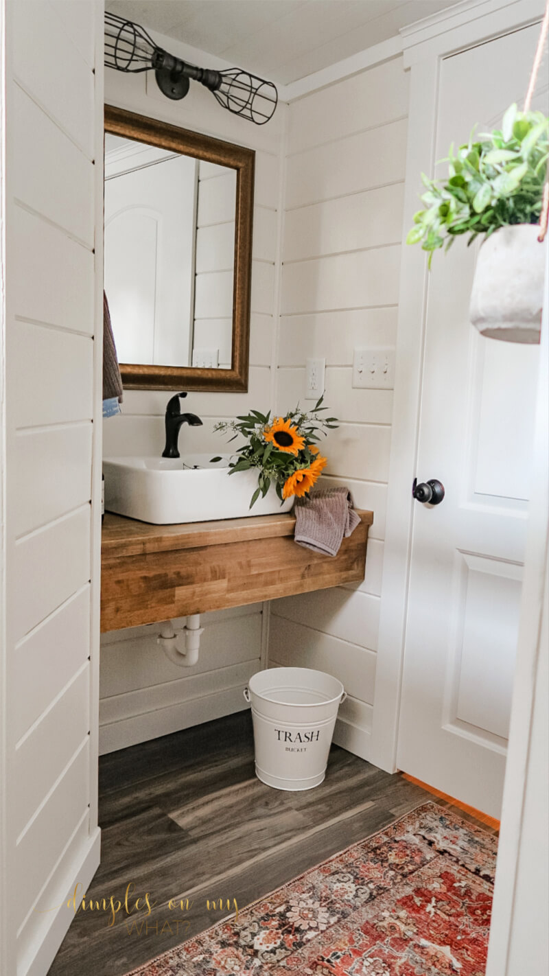 How we created a modern farmhouse bathroom retreat in dingy basement bathroom. Where we splurged and where we saved. #bathroom #bathroomremodel #diybathroomremodel #carsiding #shiplapbathroom #bathroomdecor #bathroomdecorideas #luxuryvinylplank #sherwinwilliamsalabaster #smallvesselsink