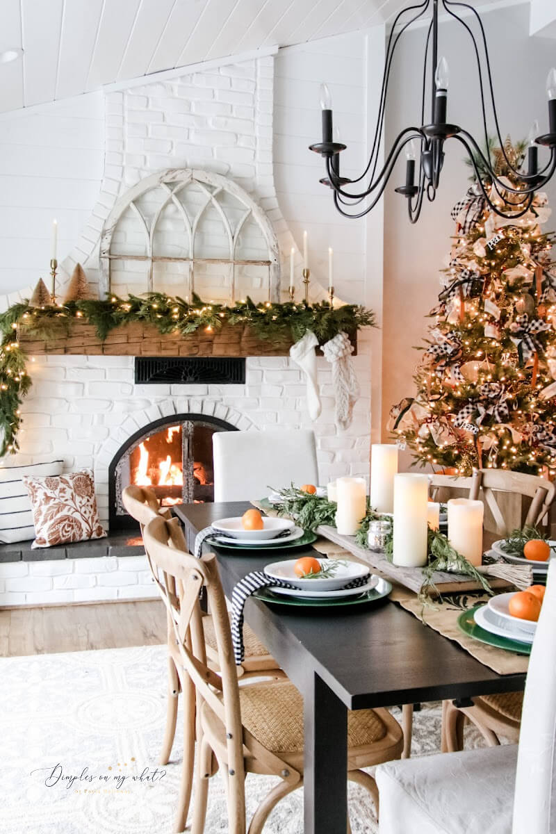 Simple table settings, a Christmas Tree, candles, and greenery are all you need to create the prettiest christmas dining room decor when a fireplace is involved.   #diningroomchristmasdecor #christmasfireplacemantledecor #fireplaceindiningroom