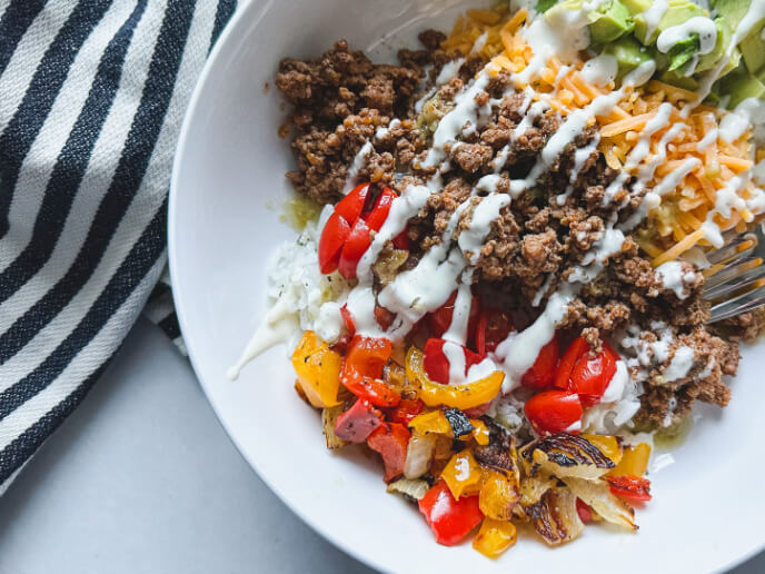 A yummy taco rice bowl filled with all the taco fillings. SO GOOD and easy to meal prep.