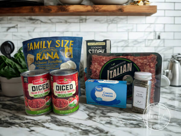 Ingredients for Easy One-Pot Weeknight dinner including, tortellini, Italian sausage, cream cheese, diced tomatoes, Italian seasoning, vegetable broth, and spinach
